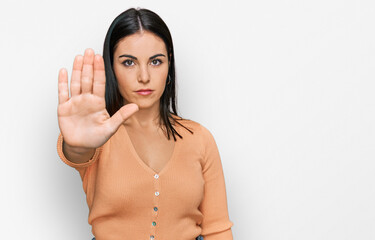 Young hispanic woman wearing casual clothes doing stop sing with palm of the hand. warning...