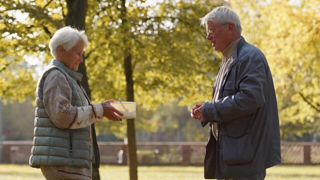 Charity event. Volunteer man giving a hot meal to an elderly woman. High quality 4k footage