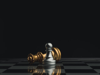 A little silver pawn chess piece standing with the win near a fallen golden queen chess piece on a...