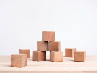 Empty wooden cube blocks on the table on white background. Many wood bricks building tower construction. Mockup composition for design