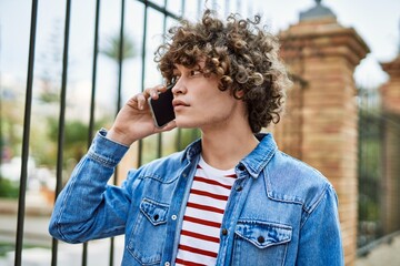 Fototapeta premium Young hispanic man speaking on the phone at the city