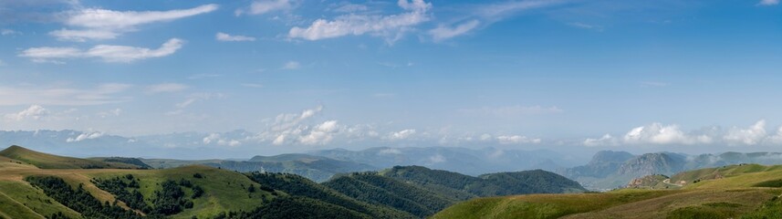 Panorama with mountains, hills and beautiful clouds