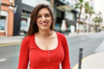 Young hispanic girl smiling happy standing at the city.