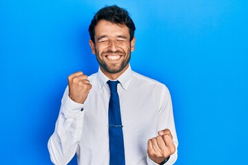Handsome man with beard wearing business shirt and tie celebrating surprised and amazed for success with arms raised and eyes closed