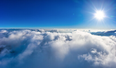 Flight through evening sky with clouds over mountain