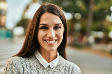 Fototapeta premium Young hispanic woman smiling happy standing at the city.