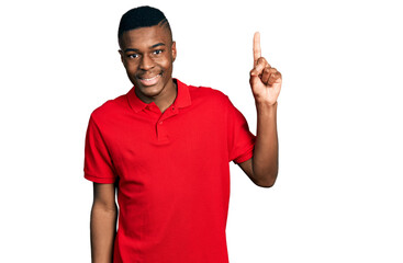 Young african american man wearing casual red t shirt showing and pointing up with finger number one while smiling confident and happy.