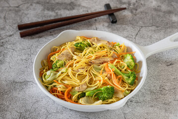 Closed up of stir fried Chinese noodle (chow mein) with pork and vegetable for lunch, tradition Chinese food
