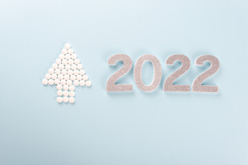 Silver colour 2022 and Christmas tree made of medication pills, tablets.