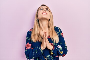 Young caucasian woman wearing casual clothes begging and praying with hands together with hope...