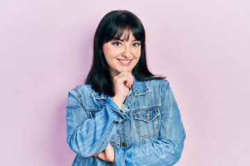 Fototapeta premium Young hispanic woman wearing casual clothes smiling looking confident at the camera with crossed arms and hand on chin. thinking positive.