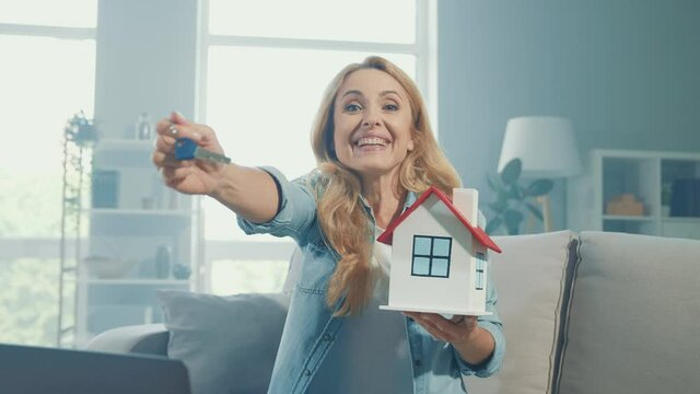 Positive reliable real estate agent hold house figure keys special flat offer