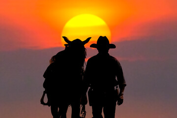 The silhouette of the cowboy and the setting sunset - 466293369
