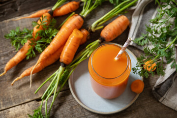 Fresh natural juice, healthy food concept. Glass jar of fresh carrot juice on a wooden rustic table. Copy space.