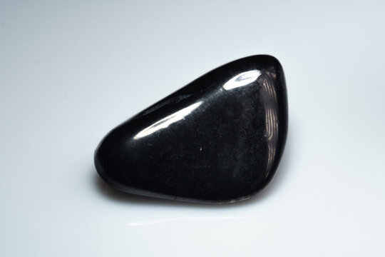 natural black shungite cabochon on the background