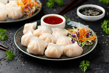 Traditional Asian Prawn or shrimp dumplings hakau, ha kauw or har gow. Served with cabbage, carrot salad and soy and sweet chilli sauce