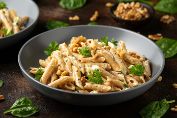 Whole Wheat Penne pasta with gorgonzola cheese sauce, spinach and walnut. Healthy food.