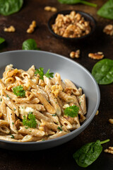 Whole Wheat Penne pasta with gorgonzola cheese sauce, spinach and walnut. Healthy food.