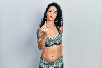 Young woman wearing bindi and traditional belly dance clothes showing middle finger, impolite and rude fuck off expression