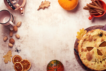 Obraz na płótnie Canvas Halloween food. Homemade pumpkin pie or tart with a scary face for Halloween on a wooden table. Copy space. Halloween food concept.