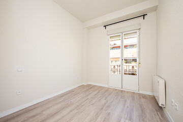 Newly painted room with bay window, wooden floors, radiator and black curtain holder
