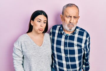 Hispanic father and daughter wearing casual clothes depressed and worry for distress, crying angry and afraid. sad expression.