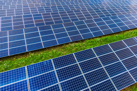 Top view of blue shiny solar photo voltaic panels system producing renewable clean energy abstract background.