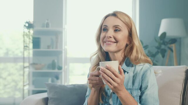 Positive blonde lady hold tea mug enjoy work pause