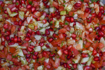 Healthy salad mixed with chopped pomegranate, cucumber,tomatoes and garnished with fresh coriander leaves