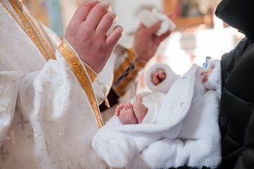 sacrament of baptism the priest baptizes the child with the anointing