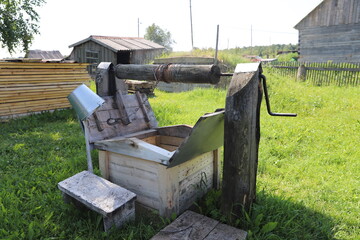 Old vintage wooden water well in a rustic farmyard on a summer day