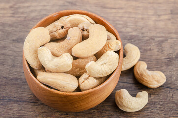 Tasty cashew nuts in wooden bowl.