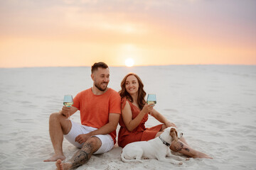 young couple in orange clothes with dog