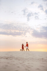 Fototapeta premium young couple in orange clothes with dog
