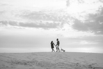 young couple in orange clothes with dog