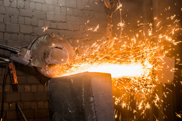 Heavy grinding equipment suspended on a chain with a hook processes and cleans cast iron reinforced...
