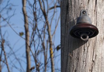 Disconnected electric power insulator hanging on utility or telephone pole