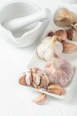 Fresh garlic bulbs on a white table.