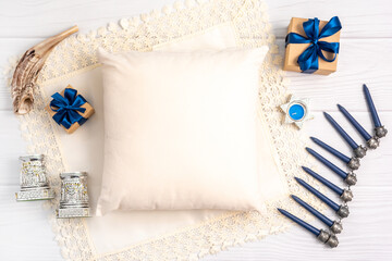 Jewish holiday Hanukkah concept with photo pillow mock up, menorah and gift box over white...