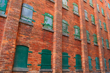 Industrial background of green door and orange brick wall