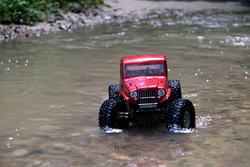 Hobby, fun sport. Radio controlled model car, trophy crossing. The car on the radio control rides on the water. Driving a typewriter