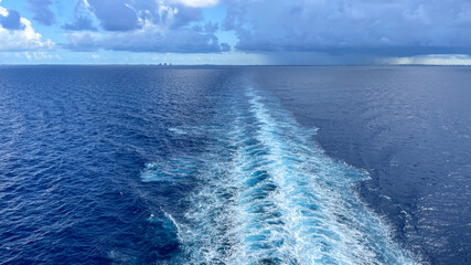 A Cruise ship wake on a beautiful stormy day with dark clouds and blue seas © Joni