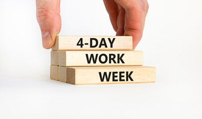 4-day work week symbol. Concept words '4-day work week' on wooden blocks. Businessman hand. Beautiful white background. Copy space. Business and 4-day work week concept.