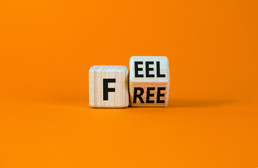 Feel free symbol. Turned a wooden cube with concept words 'Feel free' on a beautiful orange table, orange background. Copy space. Psychology and feel free concept.