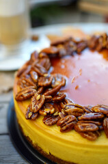 Jesienny sernik dyniowy polany słonym karmelem, posypany orzechami pekan