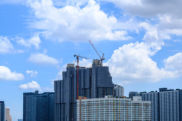 Fototapeta na wymiar Building construction, Large crane and constructions of building, Crane and building construction site against blue sky.