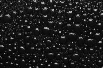 Water drops on black background texture. Dark backdrop glass covered with drops of water. black bubbles in water