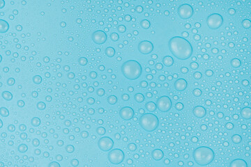 Fototapeta na wymiar Water drops on blue background texture. Backdrop glass covered with drops of water. bubbles in water
