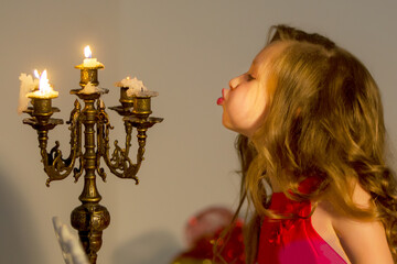 Charming Preteen Girl Blowing out Candles in Vintage Chandelier