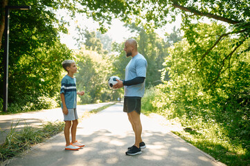 Obraz premium Father and son, football players on walking path